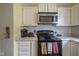 Cozy kitchen featuring a stainless steel microwave, black oven and white cabinets at 7724 Blackthorn Dr, Indianapolis, IN 46236