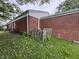 Brick home's exterior with a rustic, fenced garden area and outdoor seating on a grassy lawn at 7929 Roy Rd, Indianapolis, IN 46219