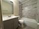 Modern bathroom featuring a vanity, toilet, and tiled shower and bathtub at 7929 Roy Rd, Indianapolis, IN 46219