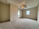 Comfortable bedroom with wood-paneled walls, neutral carpeting, a ceiling fan and bright natural light at 7929 Roy Rd, Indianapolis, IN 46219