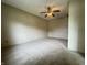Cozy bedroom with wood-paneled walls, neutral carpeting, and a ceiling fan for comfortable living at 7929 Roy Rd, Indianapolis, IN 46219