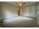 Standard bedroom featuring carpet, fan lighting, and a door to access the hallway at 7929 Roy Rd, Indianapolis, IN 46219