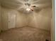 Standard bedroom featuring neutral carpet, fan lighting, and a door to access the hallway at 7929 Roy Rd, Indianapolis, IN 46219