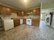 Well-lit kitchen with wooden cabinets, appliances, and views of the living room at 7929 Roy Rd, Indianapolis, IN 46219