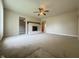 Spacious living room with a cozy fireplace and a ceiling fan, perfect for relaxation and entertaining guests at 7929 Roy Rd, Indianapolis, IN 46219