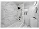 Bathroom features marble-look tile, a bathtub and shower combination, and modern black hardware at 805 N Euclid Ave, Indianapolis, IN 46201