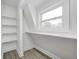 Finished attic space with hardwood floors and a built-in shelf next to a window at 815 E 24Th E St, Indianapolis, IN 46205