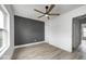 Bedroom featuring hardwood floors, a modern ceiling fan, and a doorway to the hallway at 815 E 24Th E St, Indianapolis, IN 46205