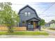 Charming house with a dark exterior, front porch, and a well-manicured lawn at 815 E 24Th E St, Indianapolis, IN 46205