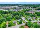 An aerial view showcases the homes in a tree-filled suburb with commercial buildings visible in the background at 8272 Calgary Ct, Indianapolis, IN 46268