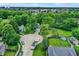 Aerial shot of home surrounded by mature trees, neighborhood, and city skyline in the distance at 8272 Calgary Ct, Indianapolis, IN 46268