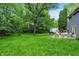 Expansive backyard showcasing a lawn, patio, and mature trees at 8272 Calgary Ct, Indianapolis, IN 46268