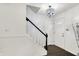 Bright foyer with a decorative chandelier, staircase with dark wood trim, and hardwood floors at 8272 Calgary Ct, Indianapolis, IN 46268