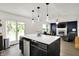 Open kitchen with a black island, white countertop, and stainless steel appliances at 8272 Calgary Ct, Indianapolis, IN 46268