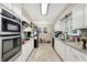 Well-lit kitchen with stainless steel appliances, white cabinets, and tile backsplash at 8301 E County Road 801 S, Plainfield, IN 46168
