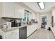 White cabinets, granite countertops, and stainless steel dishwasher in this eat-in kitchen at 8301 E County Road 801 S, Plainfield, IN 46168