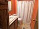 Bathroom with vanity, toilet, shower with curtain, and light orange walls at 8310 Dog Trot Ln, Morgantown, IN 46160