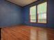 Bedroom with blue walls, vinyl flooring, and natural lighting through the windows at 8310 Dog Trot Ln, Morgantown, IN 46160
