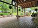 Relaxing covered porch featuring a swing, hanging plants, and a view of the landscaped yard at 8310 Dog Trot Ln, Morgantown, IN 46160