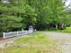 Quaint home featuring a classic white picket fence, trees, and a gravel driveway at 8310 Dog Trot Ln, Morgantown, IN 46160