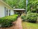 Inviting front yard with a charming brick pathway leading to the covered porch and lush landscaping at 8310 Dog Trot Ln, Morgantown, IN 46160