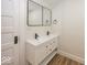 Bathroom featuring double vanity sinks with modern fixtures, mirrors and wood-style flooring at 839 N Oxford St, Indianapolis, IN 46201