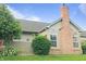 Charming home featuring a brick chimney, well-maintained lawn, and lush landscaping at 855 Gazebo Way # C, Greenwood, IN 46142