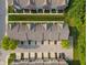 Aerial view showcasing townhome community layout, landscaping, parking, and roof lines at 9090 Demarest Dr, Fishers, IN 46038