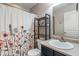 Simple and functional bathroom featuring a floral shower curtain and space-saving shelving at 9090 Demarest Dr, Fishers, IN 46038