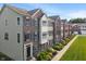 Exterior view of brick and siding townhomes in a well-maintained community with sidewalks and lawns at 9090 Demarest Dr, Fishers, IN 46038