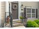 Charming front door with wreath and potted flowers sits along a nicely landscaped walkway at 9090 Demarest Dr, Fishers, IN 46038