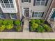 Inviting townhome entrance with landscaped garden, front door wreath, and covered porch at 9090 Demarest Dr, Fishers, IN 46038