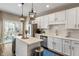 Modern kitchen with white cabinets, stainless steel appliances, quartz countertops, and island with backyard access at 9090 Demarest Dr, Fishers, IN 46038
