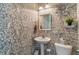 Charming powder room featuring unique wallpaper, a pedestal sink, and modern fixtures at 9090 Demarest Dr, Fishers, IN 46038