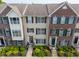 An aerial view shows three brick and tan townhomes with symmetrical windows and well-kept landscaping at 9090 Demarest Dr, Fishers, IN 46038