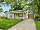 Inviting single-story home with a covered porch, attached garage, and a lush green lawn at 910 Lonsvale Dr, Anderson, IN 46013