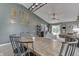 Open dining area with rustic wooden table and view to the living room with sliding glass door at 933 Curlew Ln, Greenwood, IN 46143