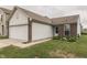View of the front exterior of the house with a two-car garage and grassy lawn at 933 Curlew Ln, Greenwood, IN 46143
