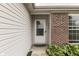 Close-up of the white front door with glass, brick accents, and landscaping at 933 Curlew Ln, Greenwood, IN 46143