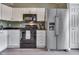 Updated kitchen features stainless steel refrigerator, white cabinets, and black appliances at 933 Curlew Ln, Greenwood, IN 46143