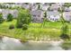 Aerial view of a large backyard with a fire pit, deck, mature trees, and lake access at 9358 W Rising Sun Dr, Pendleton, IN 46064
