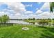 Beautiful backyard view overlooking a serene lake with a fire pit and lush green lawn at 9358 W Rising Sun Dr, Pendleton, IN 46064