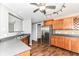 Well-lit kitchen with wood cabinets, stainless steel appliances, and wood-look flooring at 9358 W Rising Sun Dr, Pendleton, IN 46064