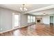 Living room with wood-look flooring, brick fireplace and backyard access at 9358 W Rising Sun Dr, Pendleton, IN 46064