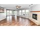Open-concept living room with stone fireplace, backyard access, and wood-look flooring at 9358 W Rising Sun Dr, Pendleton, IN 46064