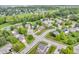 Panoramic aerial view of a residential neighborhood featuring mature trees and a nearby pond at 9754 Bradford Knoll Dr, Fishers, IN 46037