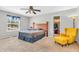 A spacious bedroom with neutral walls, a ceiling fan, and large window with a comfortable seating area and closet at 9754 Bradford Knoll Dr, Fishers, IN 46037