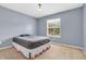 A simply decorated bedroom with blue walls, carpet flooring and a view through the window at 9754 Bradford Knoll Dr, Fishers, IN 46037