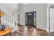 Bright foyer showcasing a dark front door, wood-look floors, and staircase access at 9754 Bradford Knoll Dr, Fishers, IN 46037