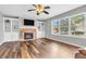 Inviting living room features a stone fireplace, built-in shelving, wood floors, and natural light at 9754 Bradford Knoll Dr, Fishers, IN 46037